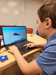 A student intently focuses on a laptop screen, displaying a stop motion animation they are working on.