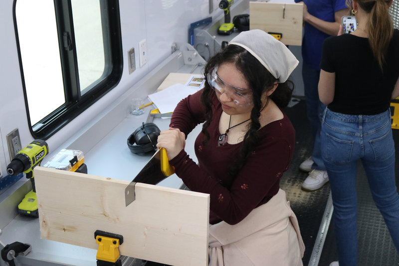 Here's one of our students trying their hand at a woodworking project during a Reach carpentry event.